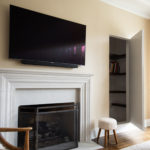 Flat screen TV on yellow wall in living room